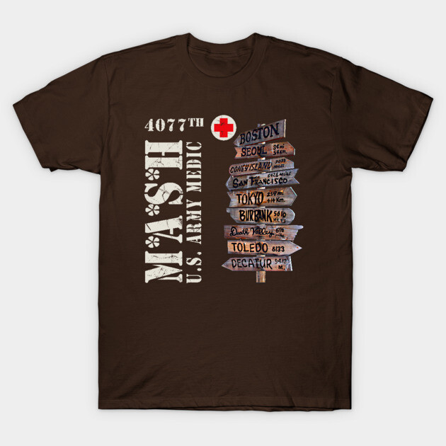 Brown MASH-themed t-shirt with vintage military design, featuring directional signs and text, casual cotton wear.