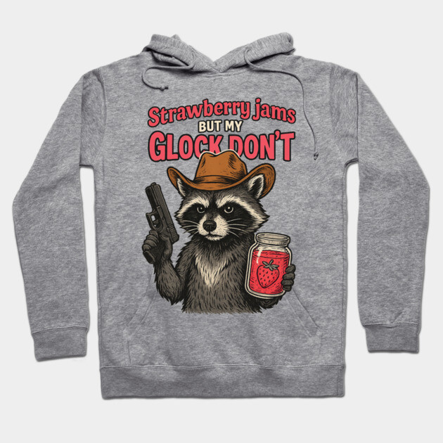 Gray hoodie with raccoon graphic, cowboy hat, holding jam jar and toy gun, text "Strawberry jams but my Glock don't".