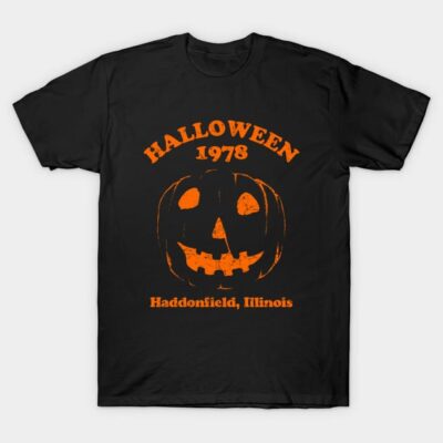 Black Halloween T-shirt with orange pumpkin design, "Halloween 1978" text, and "Haddonfield, Illinois" print.