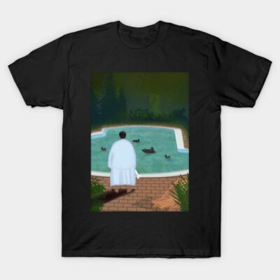 Black t-shirt featuring a serene poolside illustration with ducks and figure in white robe, casual wear, cotton fabric.
