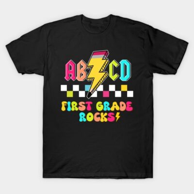 Black t-shirt with colorful "First Grade Rocks" graphic and lightning bolt design, perfect for kids' schoolwear.