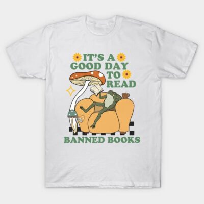 White t-shirt with "It's a Good Day to Read Banned Books" print, featuring a frog on a couch with mushrooms.