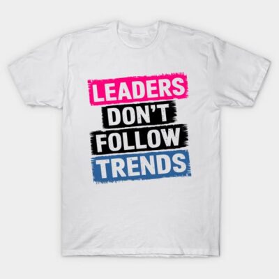 White t-shirt with bold text "Leaders Don't Follow Trends" in pink, black, and blue, casual style, cotton material.