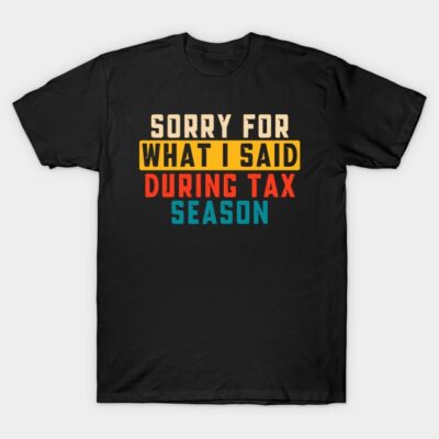 Black t-shirt with humorous "Sorry for What I Said During Tax Season" text in multicolor bold font, casual wear.