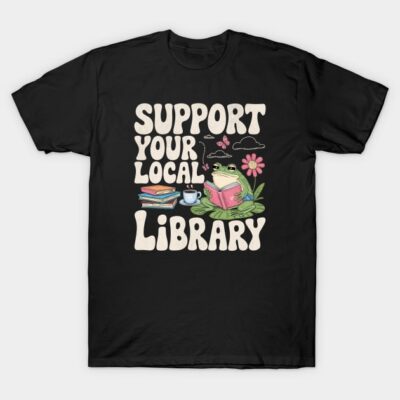 Black T-shirt with "Support Your Local Library" design, featuring a frog reading, books, and a flower. Casual style.