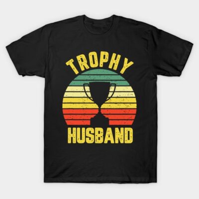 Black cotton T-shirt with "Trophy Husband" text and retro trophy design in multicolor stripes, casual wear.