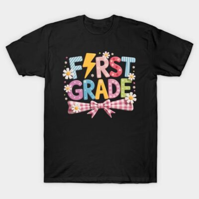 Black "First Grade" graphic T-shirt with colorful text, daisies, and bow design; perfect for kids' school attire.