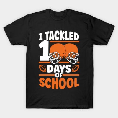 Black t-shirt with "I Tackled 100 Days of School" design featuring orange football helmets and text, cotton fabric.