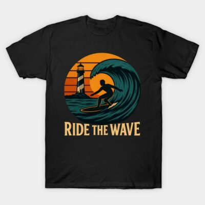 Black t-shirt with surfer and wave graphic, orange sunset background. "Ride the Wave" text. Casual beachwear.