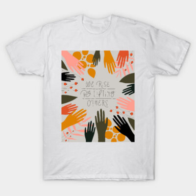 White T-shirt with colorful hand graphic and "We Rise By Lifting Others" text, cotton material, unisex casual wear.