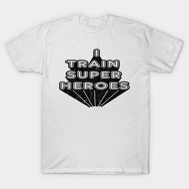 White cotton t-shirt with "I Train Superheroes" text in bold black font, casual style for everyday wear.