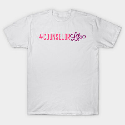 White cotton t-shirt with pink and purple "#CounselorLife" text, casual style, ideal for counselors and everyday wear.