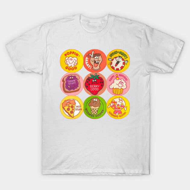 White t-shirt with colorful retro food graphic design, featuring various snacks and text slogans, casual style.