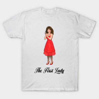 White t-shirt with "The First Lady" text and illustration of woman in red dress. Casual wear, cotton material.