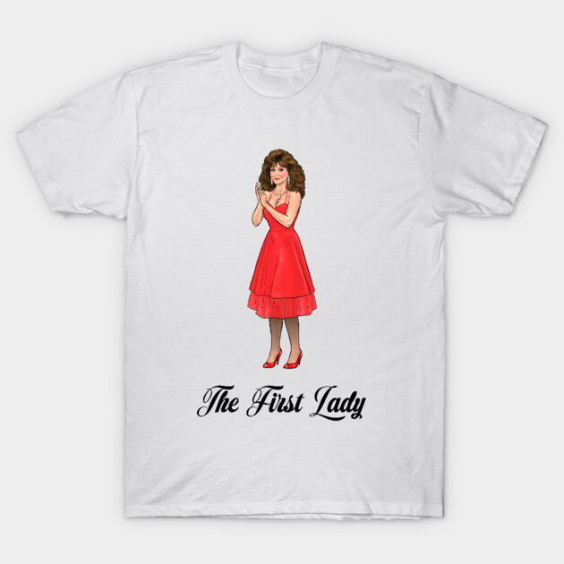 White t-shirt with "The First Lady" text and illustration of woman in red dress. Casual wear, cotton material.