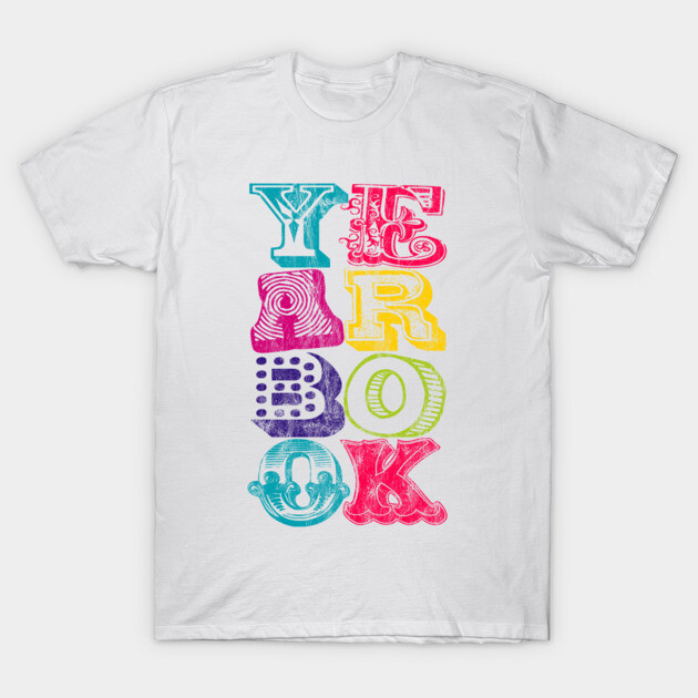 White t-shirt with colorful "Yearbook" graphic design in various fonts, casual wear, cotton material.