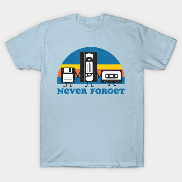 Light blue t-shirt with retro "Never Forget" graphic featuring floppy disk, VHS, cassette; nostalgic tech design.