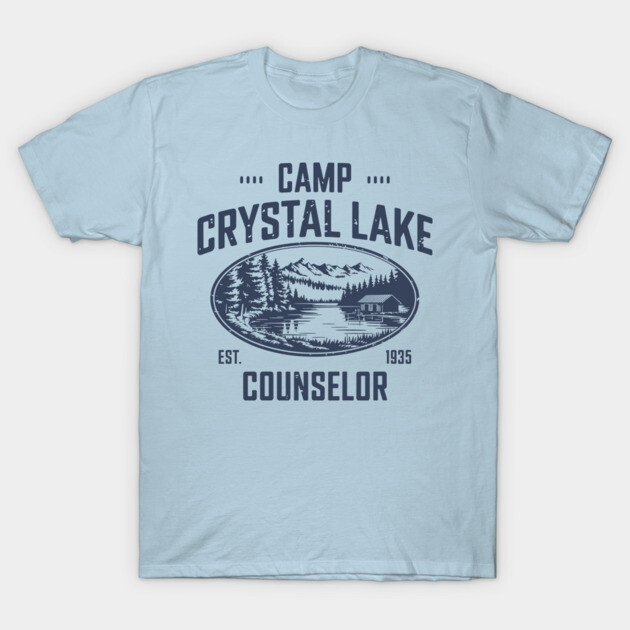 Light blue graphic t-shirt with "Camp Crystal Lake Counselor" design, featuring a scenic lake and forest illustration.