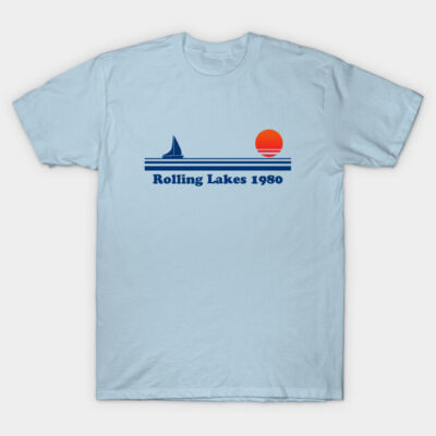 Light blue t-shirt with "Rolling Lakes 1980" design, featuring a sailboat and sunset graphic, casual cotton wear.