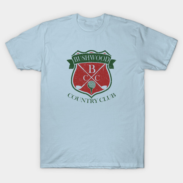 Light blue t-shirt with red and green Bushwood Country Club logo, casual style, comfortable cotton material.