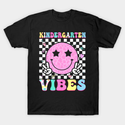 Black t-shirt with colorful "Kindergarten Vibes" graphic, featuring a pink smiley face and checkered background.