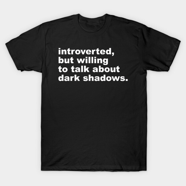 Black cotton t-shirt with white text "introverted, but willing to talk about dark shadows," casual style, unisex.