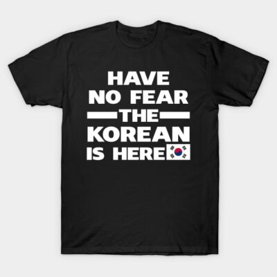 Black t-shirt with bold white text "Have No Fear The Korean Is Here" and small South Korean flag graphic. Casual style.
