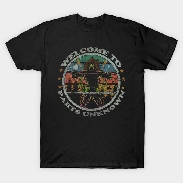 Black graphic t-shirt with retro design, "Welcome to Parts Unknown" text, featuring a colorful wrestling theme.