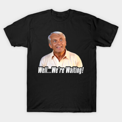 Black graphic t-shirt with "Well... We're Waiting!" quote, featuring a surprised expression. Casual wear, cotton material.