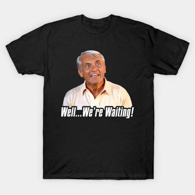 Black graphic t-shirt with "Well... We're Waiting!" quote, featuring a surprised expression. Casual wear, cotton material.