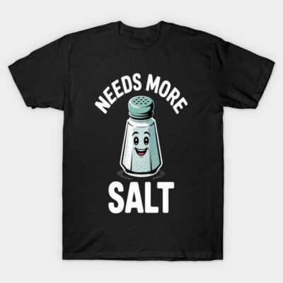Black t-shirt with humorous "Needs More Salt" graphic featuring a smiling salt shaker, casual wear, cotton fabric.