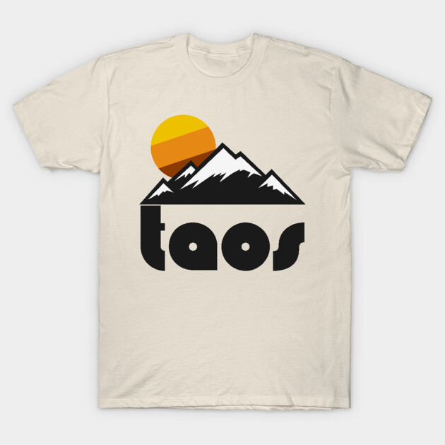 Beige t-shirt with mountain sunset graphic and "Taos" text, casual cotton style for outdoor enthusiasts.