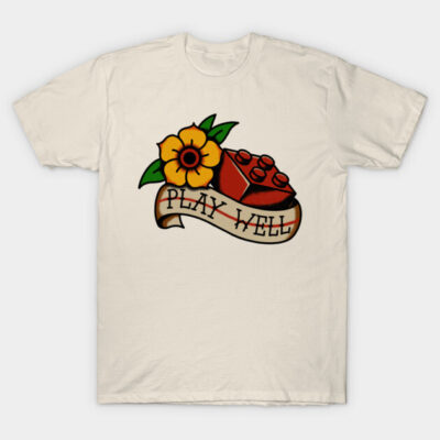 Cream t-shirt with vintage tattoo-style design featuring red toy brick, yellow flower, and "Play Well" banner.
