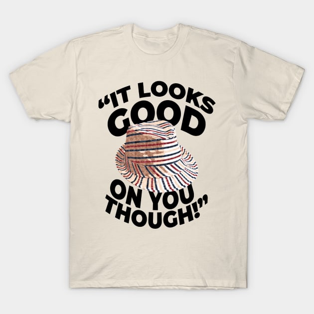 Beige t-shirt with striped hat graphic and text "It Looks Good on You Though," casual wear, cotton blend, unisex style.