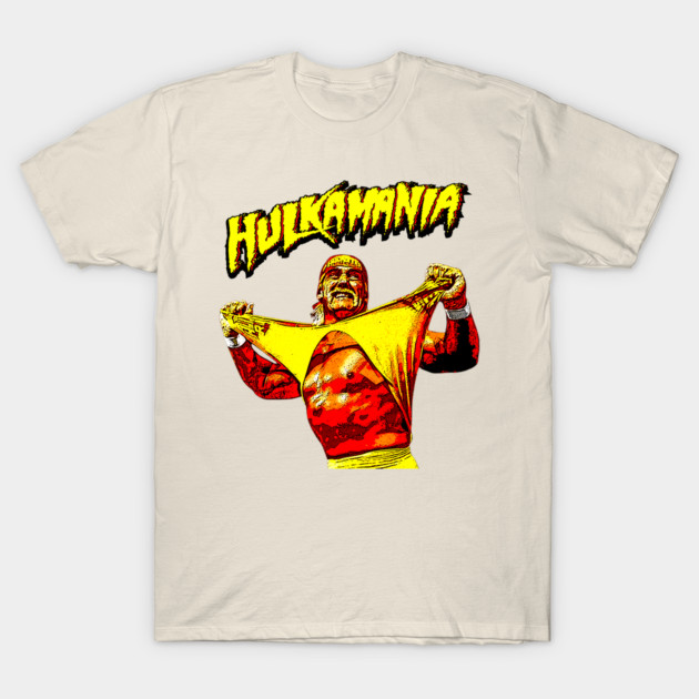 Cream t-shirt with "Hulkamania" graphic, featuring bold yellow and red design, ideal for casual wear and wrestling fans.