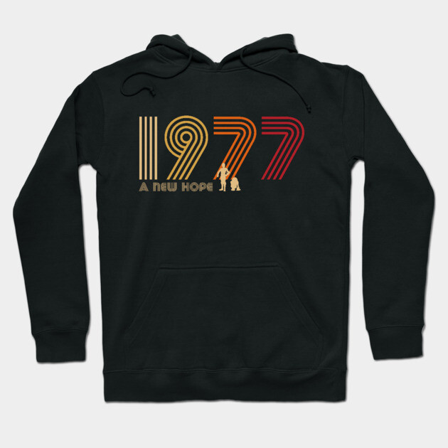 Black 1977-themed hoodie with retro-style text design, ideal for casual wear. Cozy and stylish cotton blend material.