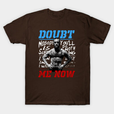Brown graphic t-shirt with bold "Doubt Me Now" text in blue and red, featuring a monochrome design for casual wear.