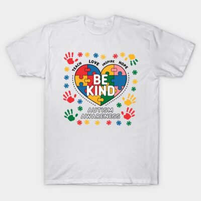White autism awareness T-shirt with colorful puzzle heart and "Be Kind" message, made from soft cotton.