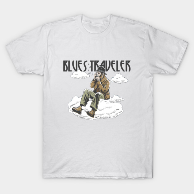 White t-shirt featuring "Blues Traveler" graphic, showcasing a musician on a cloud, perfect for casual wear.