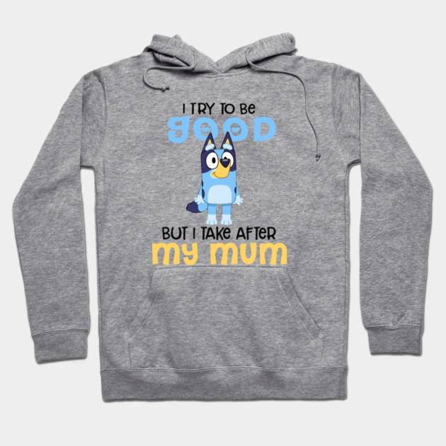 Gray hoodie with playful blue cartoon character, "I Try To Be Good But I Take After My Mum" text, casual style.