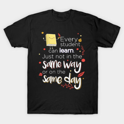 Black motivational T-shirt with educational quote, featuring playful book graphic and colorful text design.