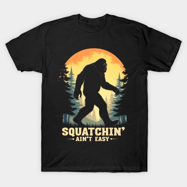 Black t-shirt with Bigfoot silhouette, forest background, and "Squatchin' Ain't Easy" text, casual wear cotton fabric.