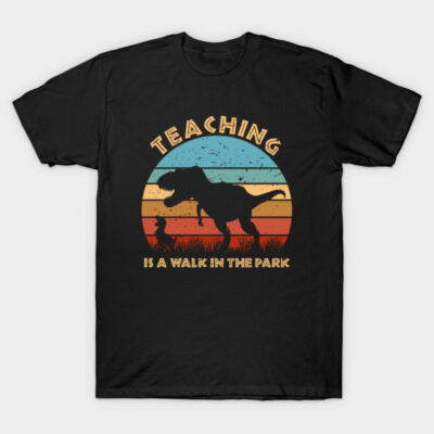 Black t-shirt with retro dinosaur graphic and "Teaching is a Walk in the Park" text, perfect for casual wear.