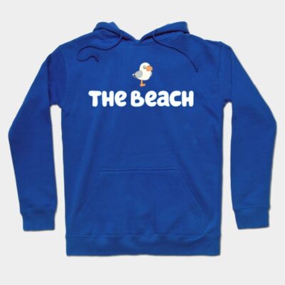 Blue hoodie with "The Beach" text and seagull graphic, casual style, cozy material, perfect for everyday wear.