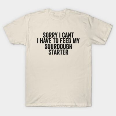 Cream T-shirt with humorous text "Sorry I Can't, I Have to Feed My Sourdough Starter" in bold black font.
