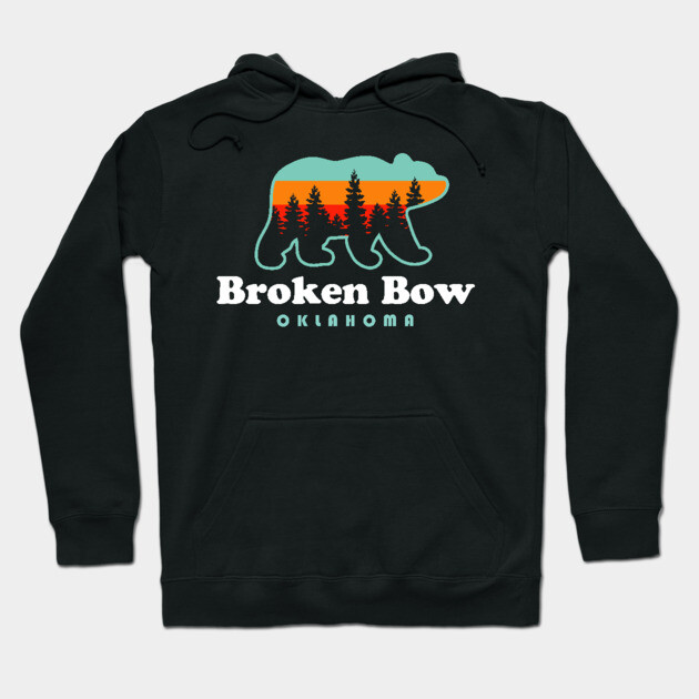 Black hoodie with "Broken Bow Oklahoma" bear design, featuring colorful forest silhouette. Cozy, casual wear.