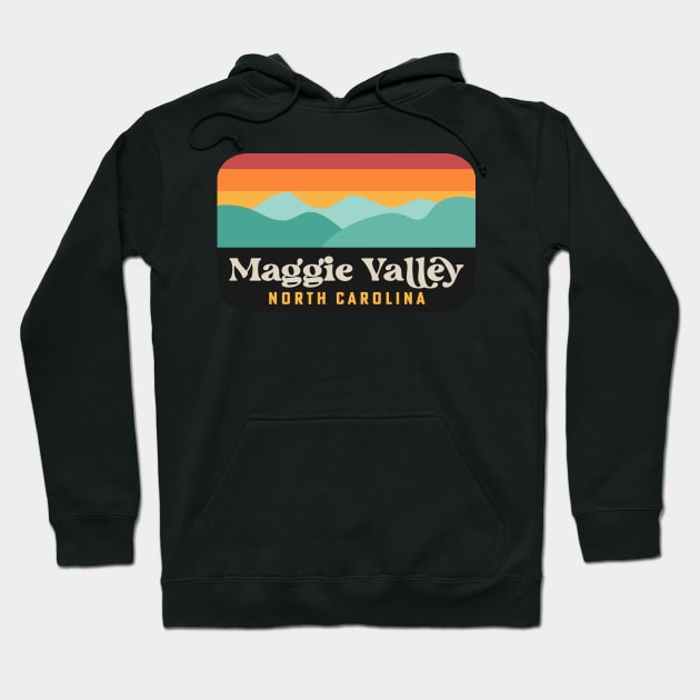Black hoodie with retro Maggie Valley North Carolina design, featuring colorful mountain landscape graphic.