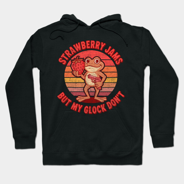 Black hoodie with retro-style frog print, "Strawberry Jams But My Glock Don't" text, casual wear, cotton blend.