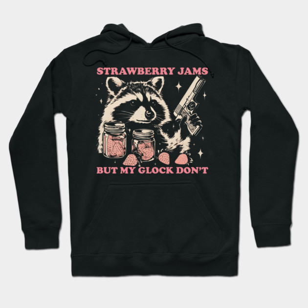 Black hoodie with raccoon graphic, jars of strawberry jam, and a playful slogan. Casual wear, cotton material.