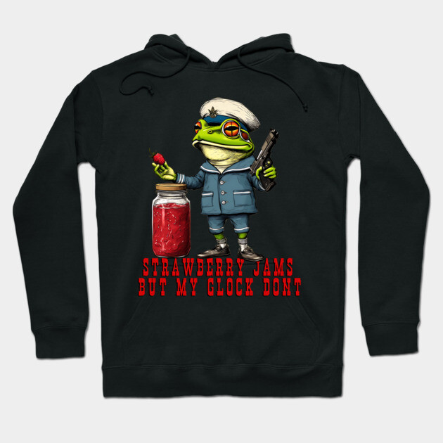 Black hoodie with a quirky frog graphic, featuring a jar of strawberry jam and humorous text. Casual and fun style.